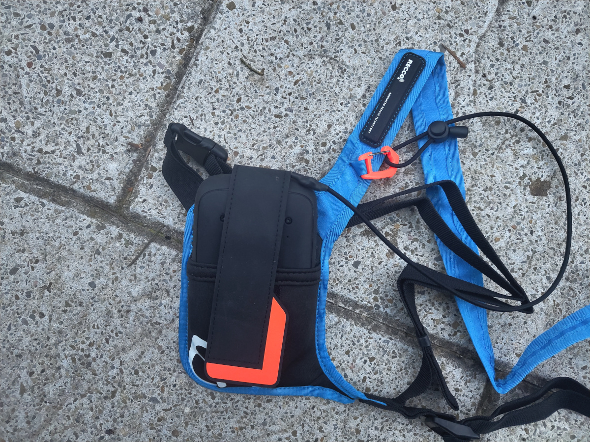 La funda de transporte, sujeta correctamente el DVA, tiene una pastilla RECCO y un pequeño mosquetón para anclar el cordón del DVA.